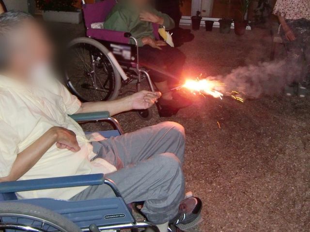 夜の交流を楽しむ様子 中庭 夜の中庭でくつろぎながら、楽しい交流の時間を過ごしています。花火で和やかな雰囲気です。