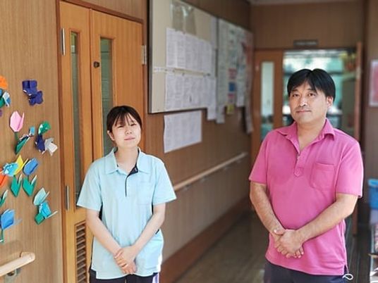 笑顔のスタッフと掲示物