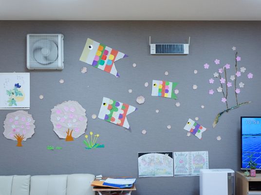壁には時計や換気扇だけでなく、紙で作られた桜や鯉のぼりなど、季節を感じられる飾り付けが施されている。