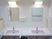 サムネイル 施設の写真 洗面台は二つ並んでいて、一つには転倒防止の手すりが付いている。大きな鏡と照明、手拭きナプキンが備わっている。