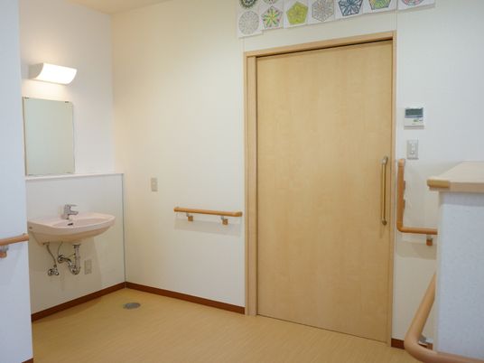 二階部分の廊下にも洗面台が設置してある。個室にはいるドアはスライド式で、ドアの上にはカラフルな絵が飾られている。