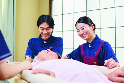 笑顔のスタッフが介助する居室