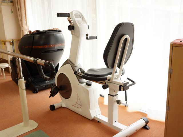 運動器具が並ぶ部屋 トレーニングルーム ゆったりとした空間でリハビリに専念できる訓練室です。健康維持のための設備が整っており、ご利用者の自立支援を手厚くサポートしています。