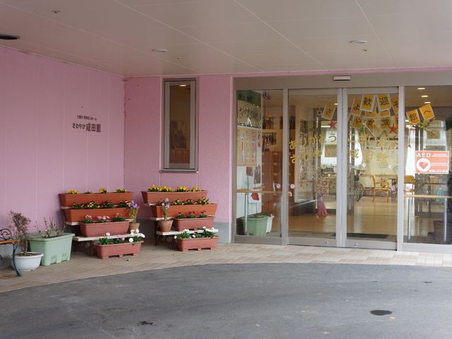 入口と花壇の外観 出入口 温かみのあるエントランスには色とりどりの花が彩りを加え、訪れる方を優しく迎え入れます。
