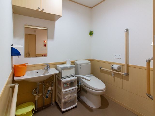バリアフリーの洗面トイレ トイレ 手すりが完備された清潔感のあるトイレです。安全にご利用いただける設計になっており、安心して就業を考えられます。