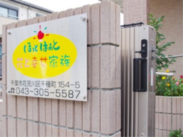 施設の看板と門柱 外観2 目を引くデザインの看板が訪れる人を温かく迎えています。連絡先も記され、お問い合わせしやすい環境が整っています。