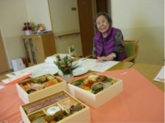 お祝いの料理と笑顔の女性