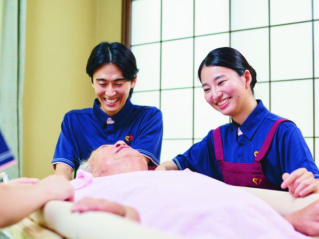 介護スタッフの様子 スタッフイメージ 笑顔のスタッフが利用者と親しみ深い交流をしています。優しい雰囲気で安心感を提供いたします。