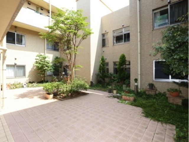 ゆったりとした緑の中庭 中庭 日差しが降り注ぐ中庭は、植物が配置され心地よい空間です。利用者の方々の憩いの場となっています。