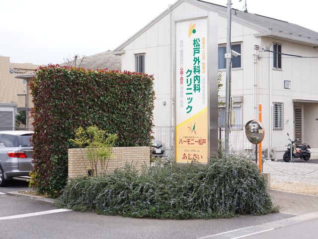 ケアハウスの看板と外観 看板 明るく見やすい看板が設置されており、温かみのある雰囲気が感じられる外観です。働く環境としてもお迎えしています。
