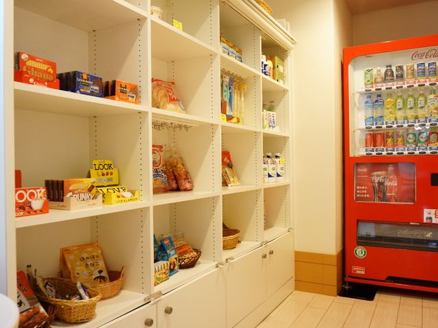 スナック売り場の棚 売店1 食堂にはお菓子や飲み物を選べる充実した売り場があり、利用者の小腹を満たすのに便利です。