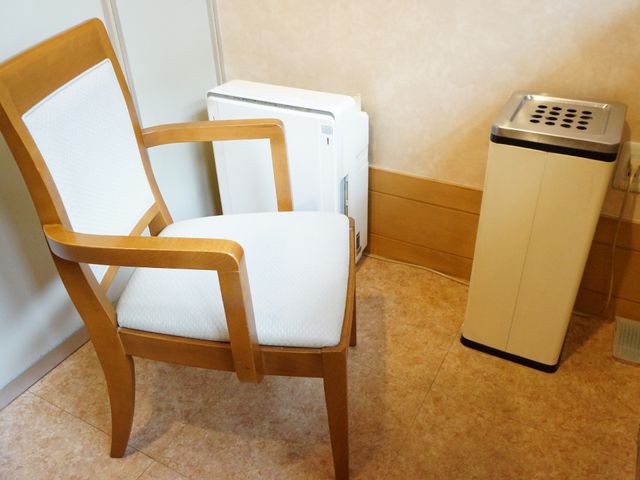 椅子とエアコンがある部屋 喫煙コーナー 清潔感のある洋室には、快適に過ごすための椅子とエアコンが設置されており、居心地の良さが感じられます。