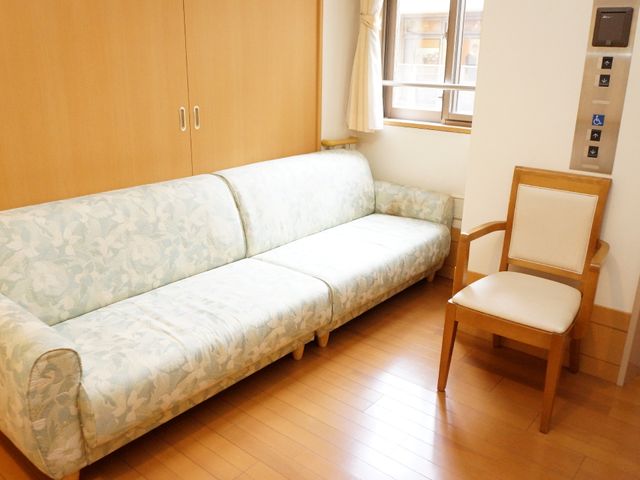 清潔な居室の一角 エレベーターホール 木目調で温もりを感じる居室です。窓際のソファでゆったりと過ごす一時をイメージしていただけます。