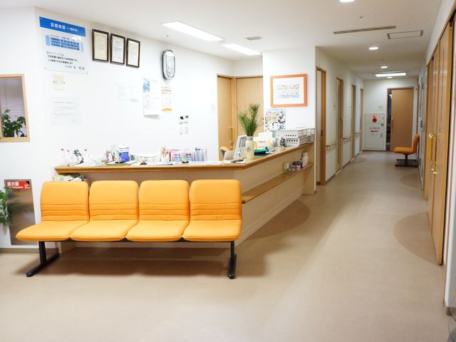 明るい受付と廊下 共有スペース 暖かみのあるカラーの座席が配置された受付エリアです。ゆったりとした待合スペースで安心してお待ちいただけます。