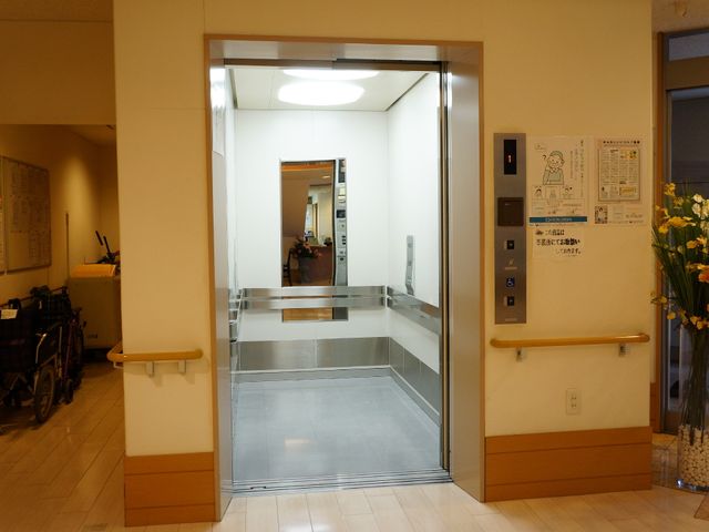 エレベーター前の開放的エントランス エレベーター エレベーターに隣接した開放的な入口は、利用者の行き来を考えたバリアフリー設計です。ゆったりとした空間が就業環境の快適さを支えています。
