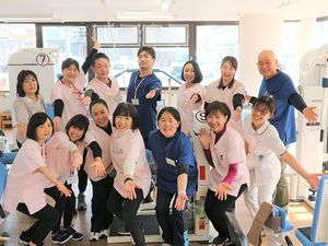 笑顔のスタッフが並ぶ機能訓練室