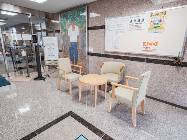 資料掲示板と椅子の廊下 廊下 気軽に座れる椅子とテーブルがあります。掲示板には有用な情報が貼られています。