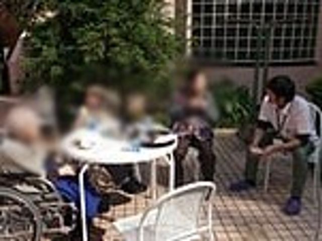 庭の交流 庭 自然に囲まれた庭で、利用者とスタッフがリラックスしながら交流している様子が見られます。