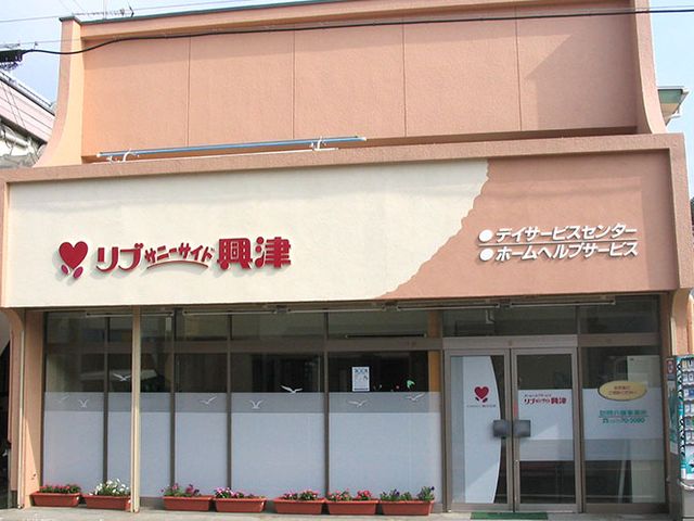 明るい看板の建物 看板 地域に根ざしたデイサービスセンターの看板です。和やかな雰囲気が感じられます。