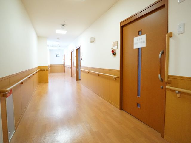 廊下の手すりと扉 廊下 手すりが設置された温かみのある廊下です。床は滑りにくく、安全に配慮された設計になっております。