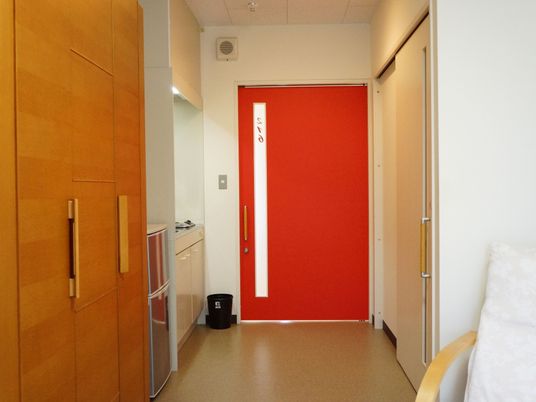 赤いスライド式のドアを開けると、簡易的なキッチンと冷蔵庫、クローゼットがある。室内には、トイレもある。