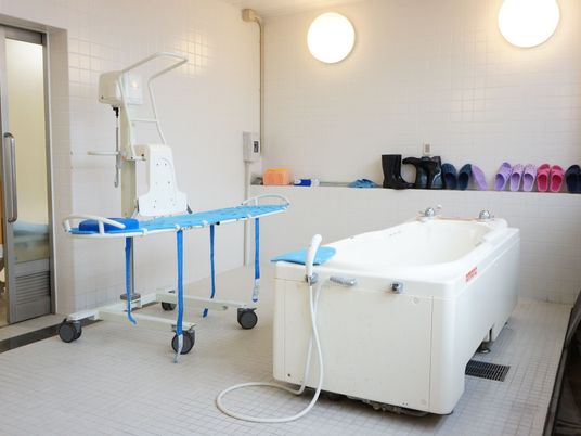 広々としたバスルームには、介護用のバスタブを完備している。室内にはストレッチャーがあり、リフトが置かれている。