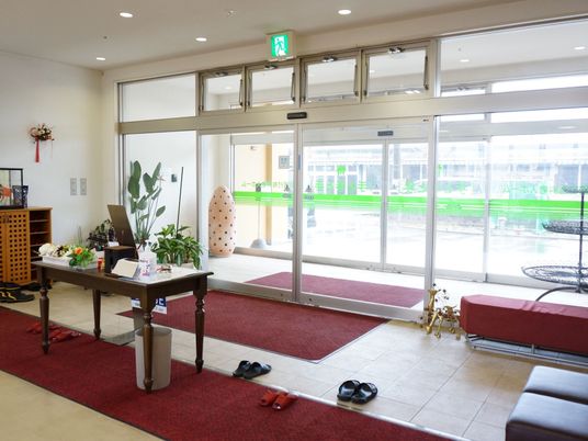 エントランスホールには風除室があり、フロアマットが敷かれている。また入り口には開口部が大きな、自動ドアを設置している。