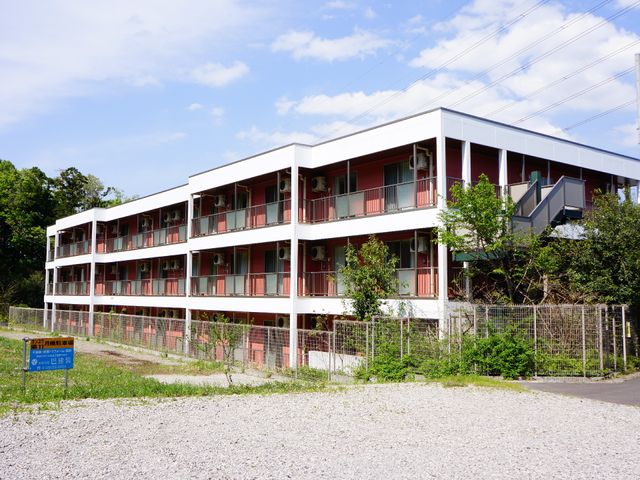三階建ての白い建物 外観 自然豊かな環境に囲まれた明るい建物です。就業を検討している方に、快適な職場環境をお約束します。