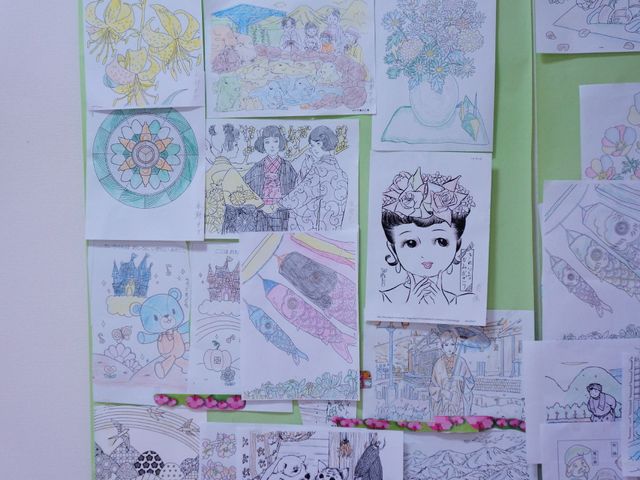 カラフルな掲示物の壁 たくさんの絵 壁に飾られた色とりどりの絵は、創作活動の充実を伝え、利用者の表現の場を提供しています。