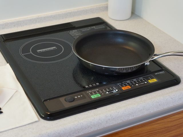 IHコンロとフライパンのキッチン コンロ 手軽に調理を楽しめる清潔感のあふれるキッチンスペースです。食事作りの時間も、居心地の良いひとときを提供します。