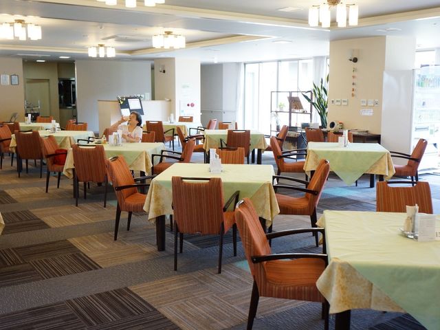 快適な食堂空間 食堂 広々とした明るい空間の食堂で、一人の方がリラックスしながらお食事をお楽しみになっています。職場には安らぎの時間を提供する食事の場があります。