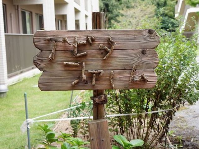 木製の素朴な看板 農園 自然な素材を生かした看板が、温かみのある迎えをしています。ここでの仕事は、心地よい環境が支えとなるでしょう。