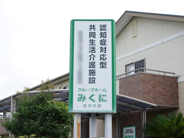 施設看板と外壁 看板 清潔感のある建物前に立つ緑色の看板。ゆとりを感じさせる外観が、訪れる方々を温かく迎え入れます。