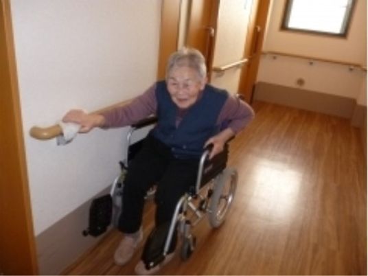 廊下で手すりを使う利用者