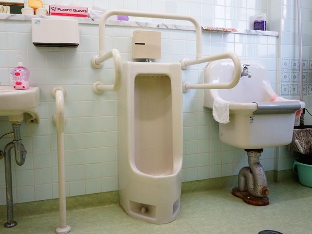 バリアフリー設計の浴室 男性用トイレ 手すりが整った安全に配慮した清潔な浴室です。利用者の移動や立ち座りをサポートし、安心してお使いいただけます。