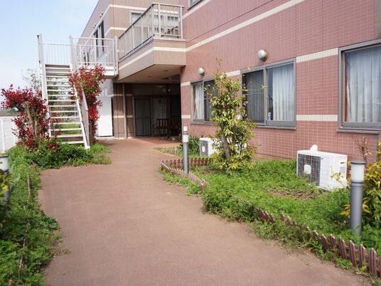 赤茶の建物と緑の庭