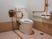 サムネイル 木目調の床は落ち着きを感じさせる。転倒防止用の柵や手すりが取り付けられており、利用者に優しいトイレとなっている。