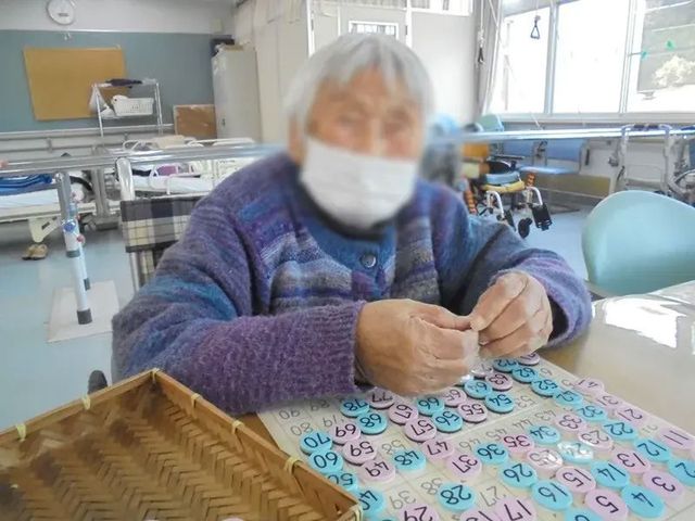 手作業をする人の様子 機能訓練室 明るい場所で楽しく手作業をしている様子です。快適な環境で集中して取り組めます。