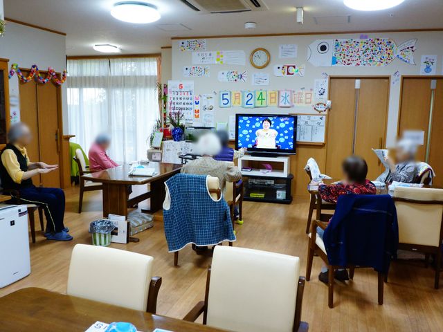 多機能共有スペース リビング1 居心地の良い共有リビングです。広々としたこの空間では、皆でテレビを楽しむ様子が伺えます。