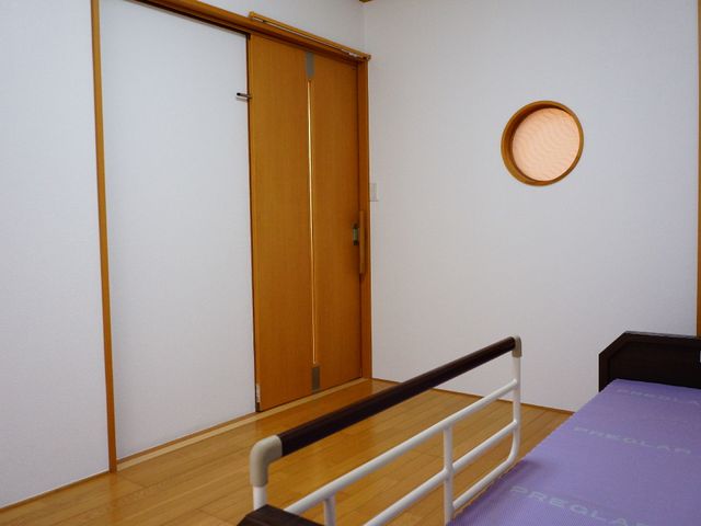 和室のベッドと扉 私室ドア 手すり付きのベッドと床の明るい色合いが心地よい居室です。円窓からは優しい光が差し込みます。