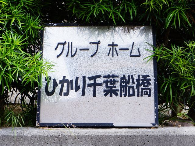 看板のクローズアップ 施設看板 訪れる方を温かく迎える明朗な雰囲気の表示看板。細やかな配慮が感じられる環境でのお仕事をご一考ください。