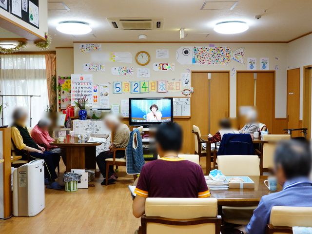 居心地の良い食堂 談話風景 ゆったりとした食堂で、利用者の方々がくつろいでいます。壁面には季節感を感じさせる飾りがあり、家庭的な雰囲気が漂います。