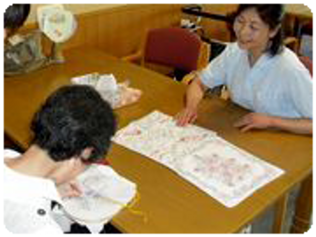 作業に取り組む居室 居室 穏やかな雰囲気の中で、スタッフが手作業をサポートしています。リラックスした環境です。
