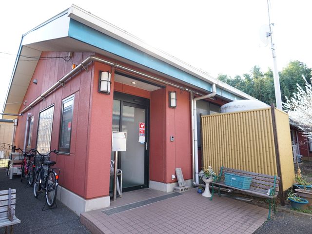 赤茶色の建物のエントランス 外観 あたたかみのある色合いのエントランスが迎えてくれます。自転車置き場も整っています。