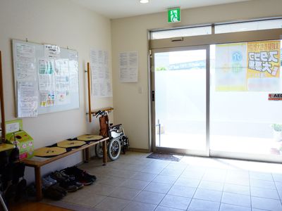 エントランスの掲示物と車椅子