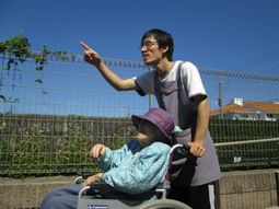 車イスの利用者とスタッフ