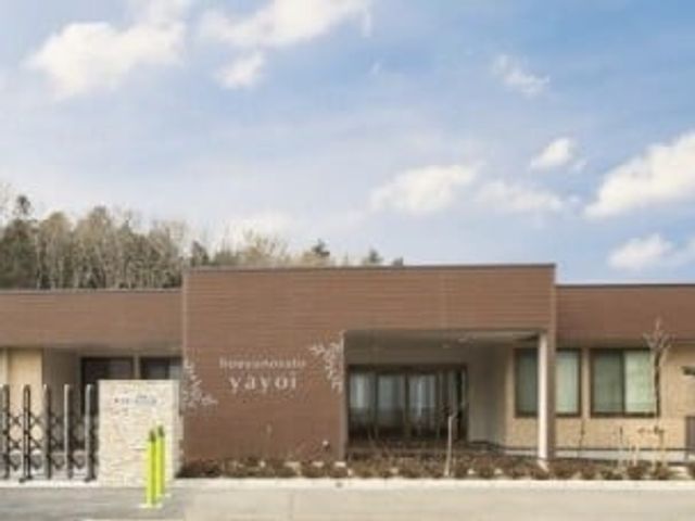 施設の外観 外観   青空の下に広がる平屋建てで、落ち着いた色合いの外壁が印象的です。正面は出入りしやすいように整えられています。