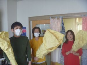 マスク姿の3人が並ぶ室内  