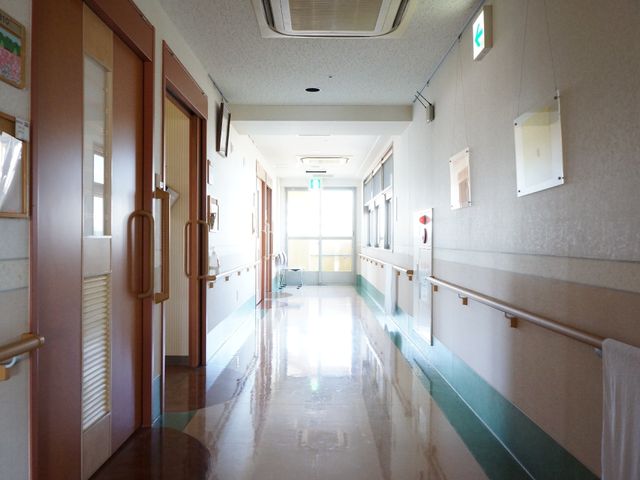 手すり付きの明るい廊下 室内 床から天井まで光が届く清潔感のあふれる通路です。手すりが整備されており、安全にお過ごしいただけます。