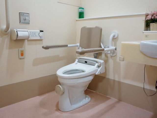 バリアフリートイレ設備 トイレ 安全に配慮された手すり付きのトイレです。助けが必要な方も安心してご使用いただける設計となっています。